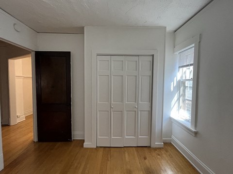 the living room of an empty house with white walls and a door