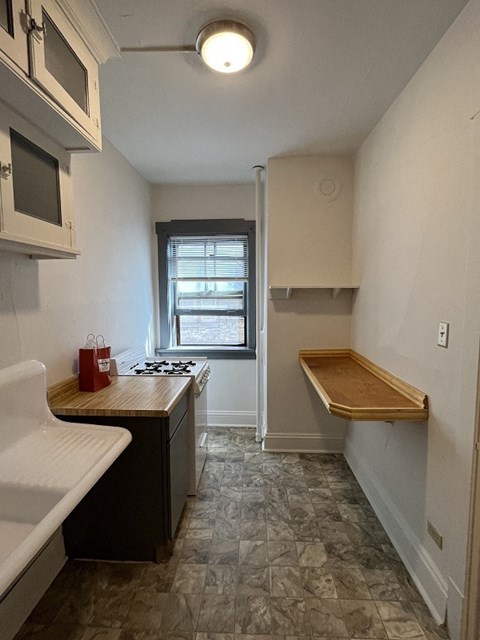 a small kitchen with a stove and a window