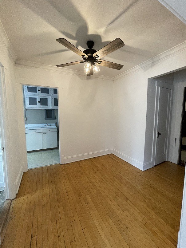 an empty living room with a ceiling fan
