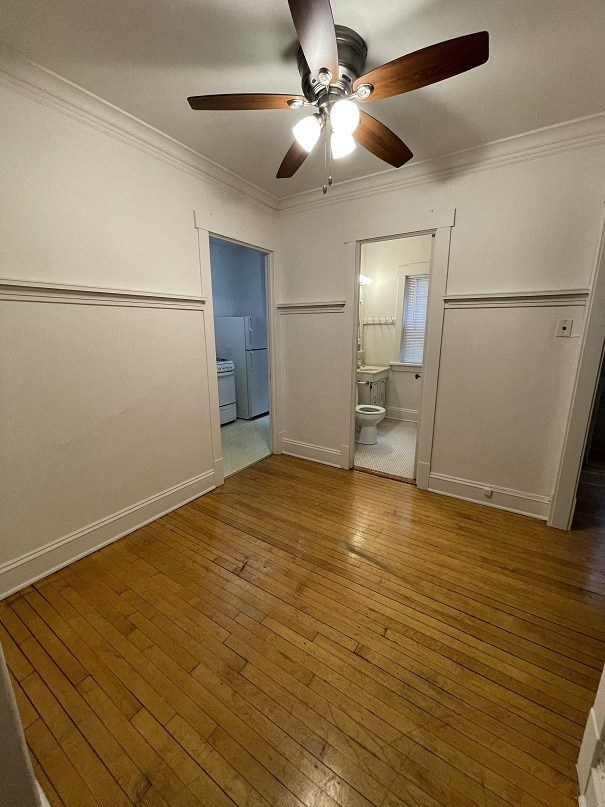 a living room with a wooden floor and a ceiling fan