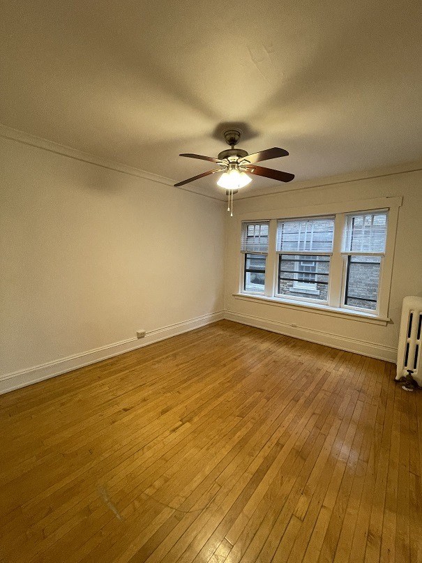 the living room of an empty house with a ceiling fan