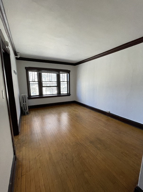an empty living room with wooden floors and a window