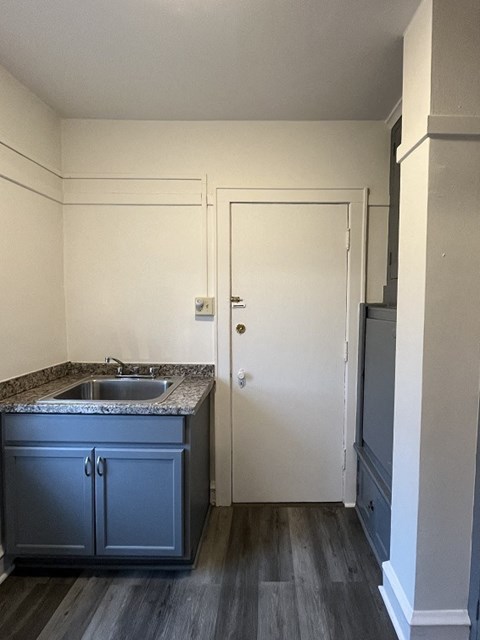 an empty kitchen with blue cabinets and a sink