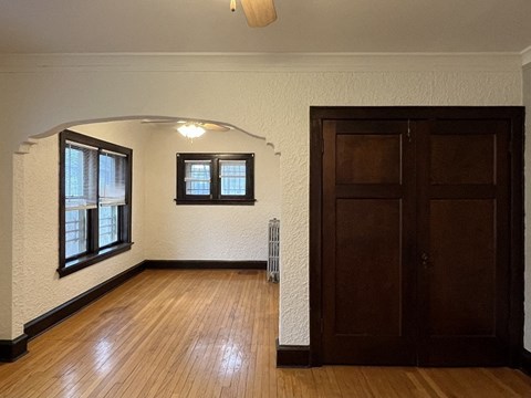 an empty living room with a wooden floor and a wooden door