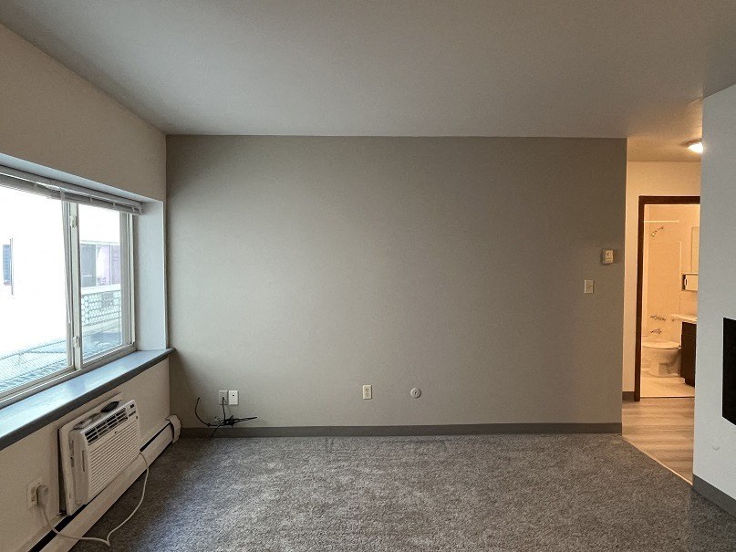 A room with a window and a heater.