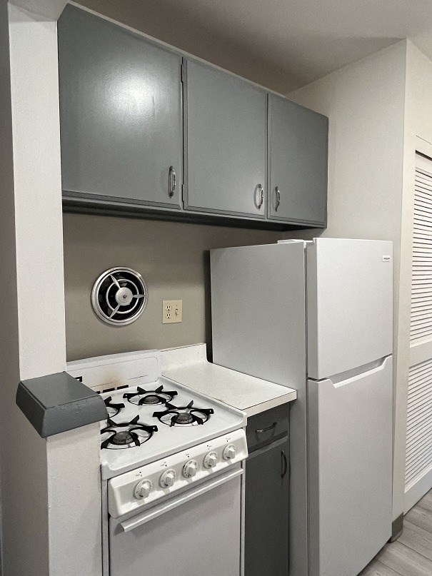 A white stove and refrigerator in a kitchen.