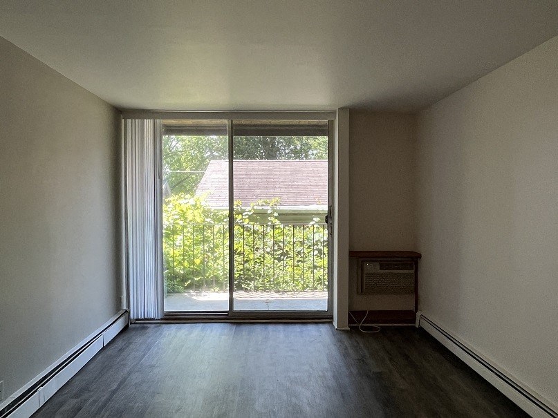 A room with a sliding glass door leading to a garden.