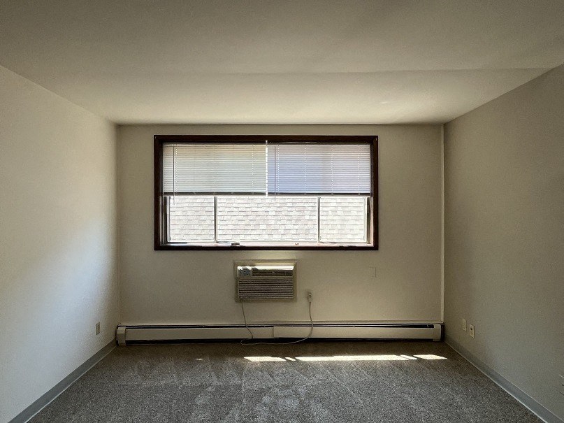 A room with a window and a heater.