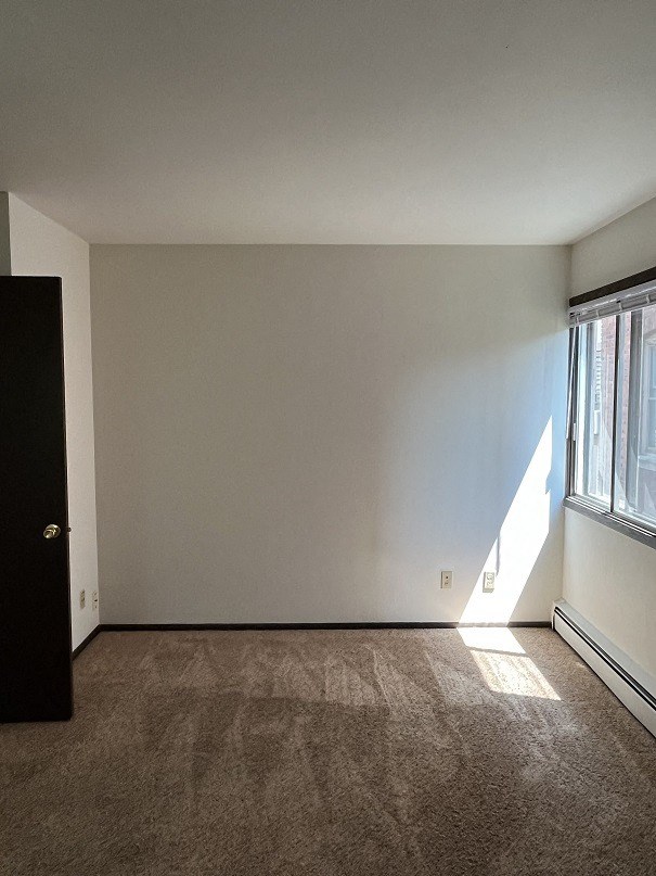 an empty room with a window and a door