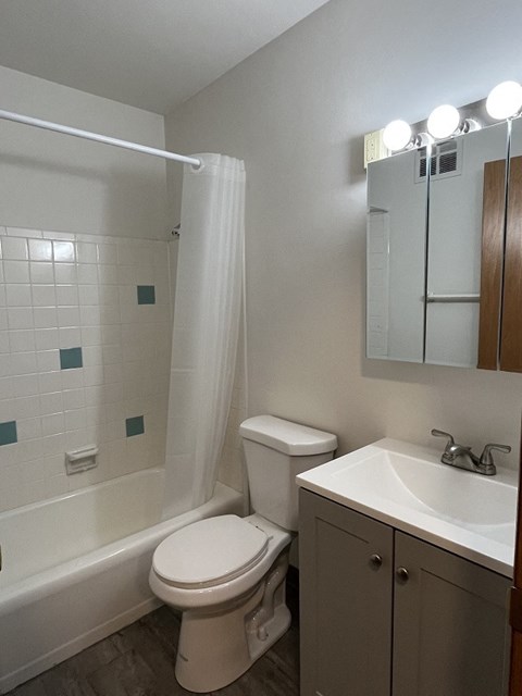 A white toilet sits next to a white sink in a bathroom.