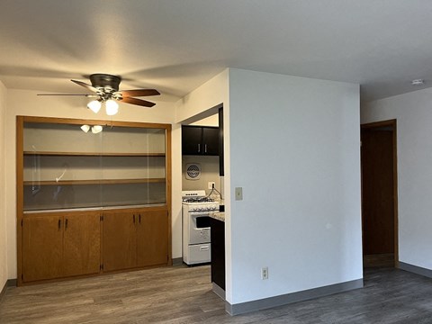 A kitchen with a white wall and a ceiling fan.