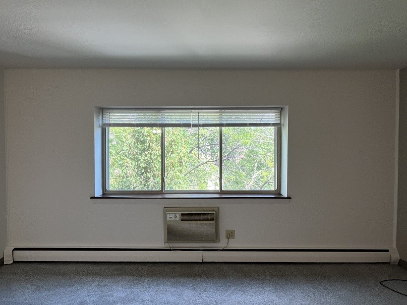 A room with a window and air conditioner.