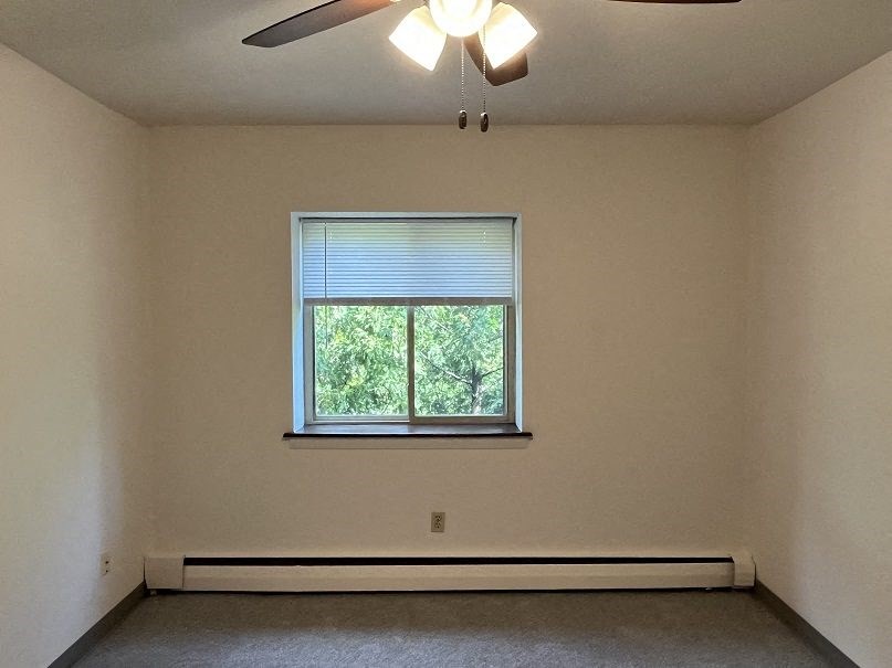 A room with a window and a ceiling fan.