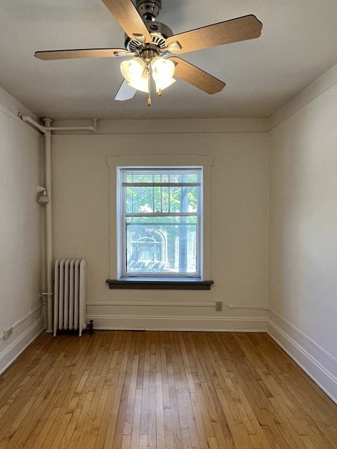 A room with a ceiling fan and a window.
