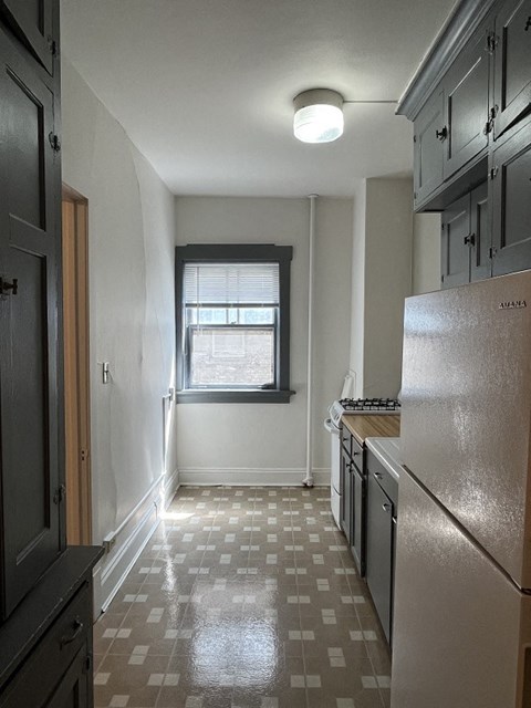 A kitchen with a checkered floor and a window.