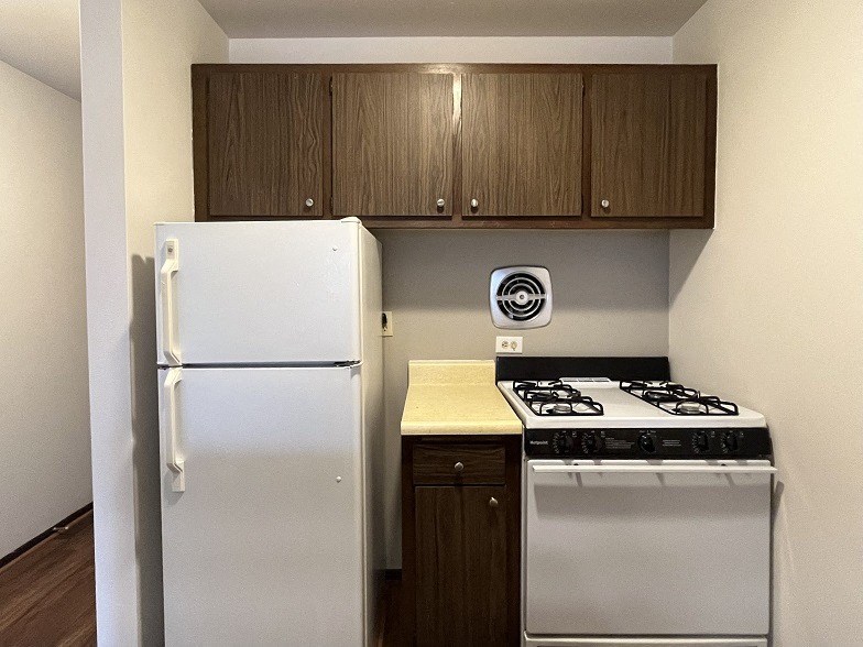 A white refrigerator and a stove in a kitchen.