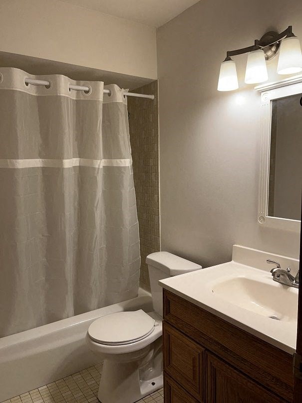 A white toilet sits next to a white sink in a bathroom.