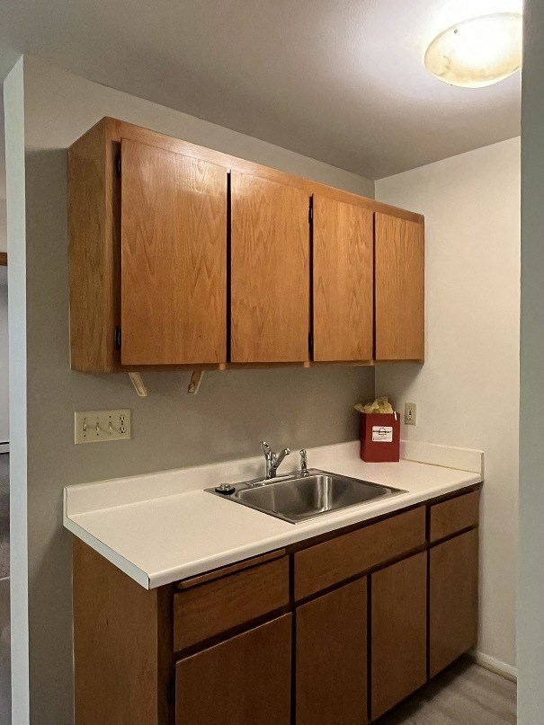 A kitchen with wooden cabinets and a white countertop.