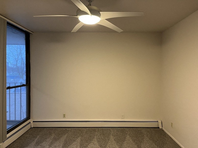 A room with a ceiling fan and a window.