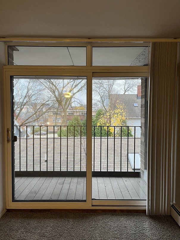 A view of a balcony through a sliding glass door.