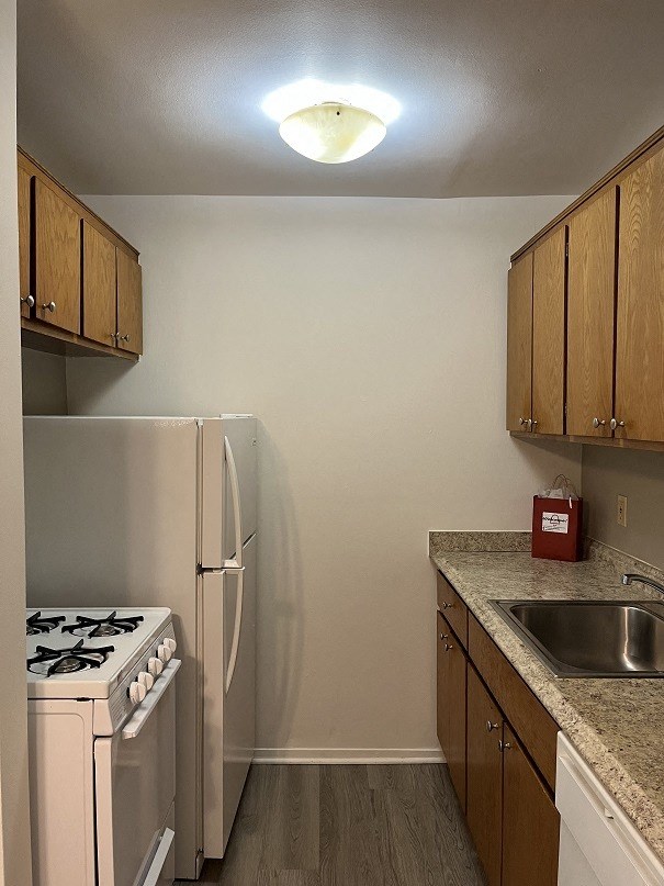 A kitchen with a white stove and a white refrigerator.