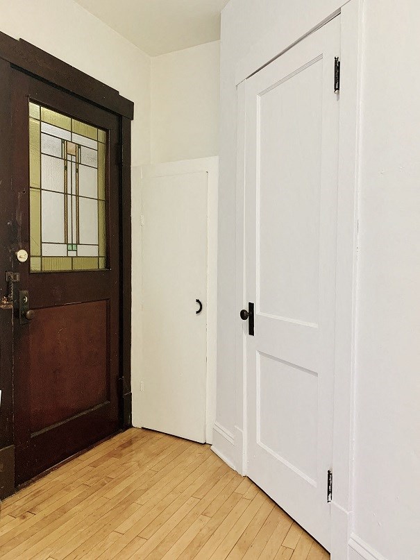a bedroom with a door and a wood floor