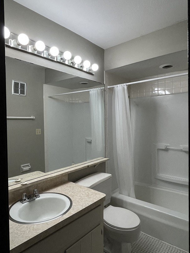 A bathroom with a sink, toilet, and bathtub.
