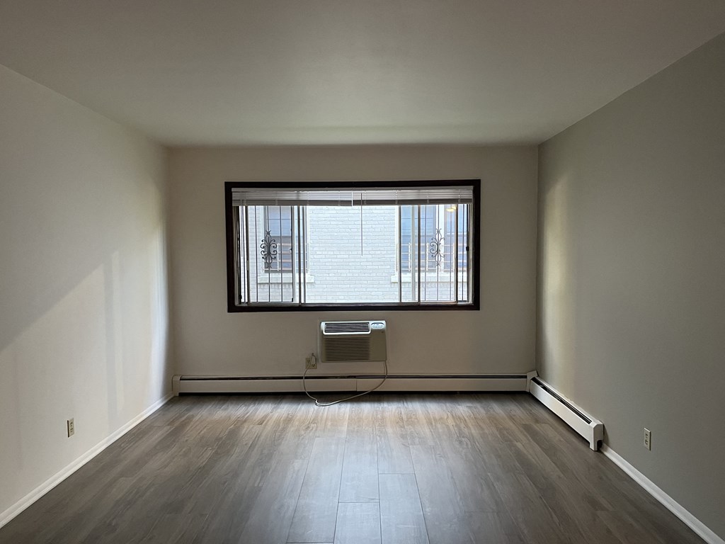 A room with a window and a radiator on the wall.