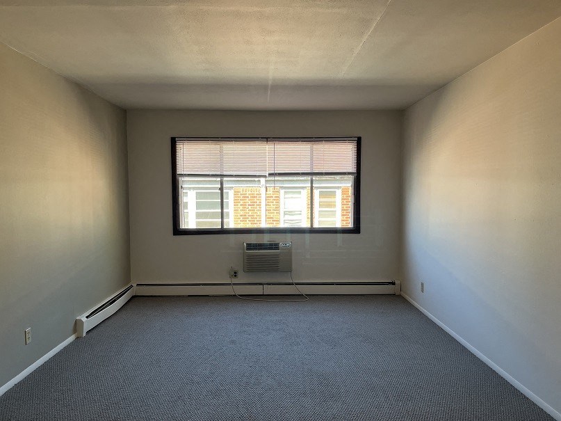 A room with a window and a radiator on the floor.