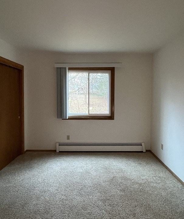 an empty room with a window and carpet