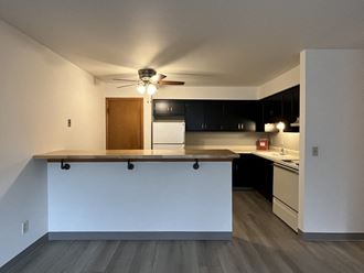 an empty kitchen with a counter and a ceiling fan