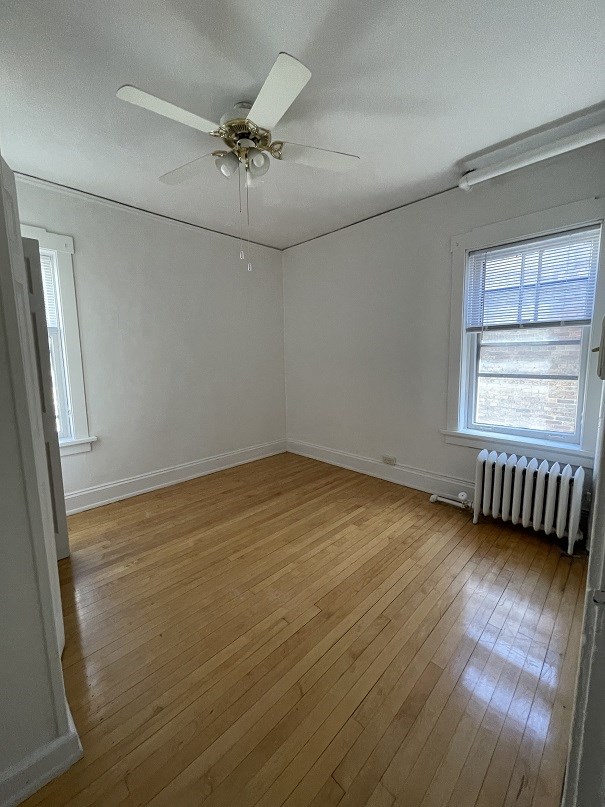 a living room with wood floors and a ceiling fan