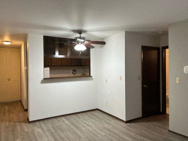 A room with a ceiling fan and a window with blinds.