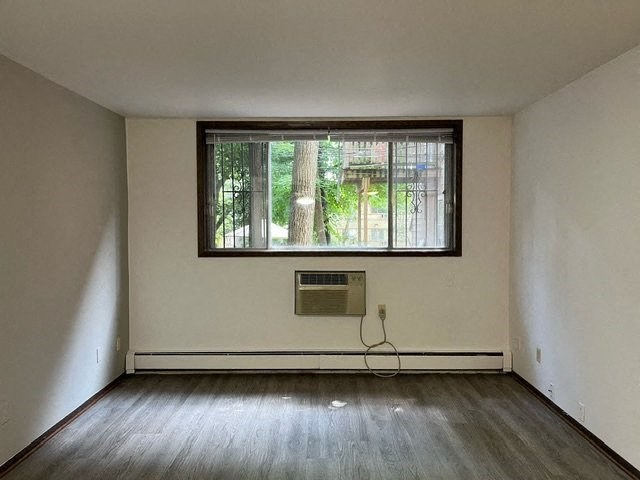 A room with a window and a wooden floor.