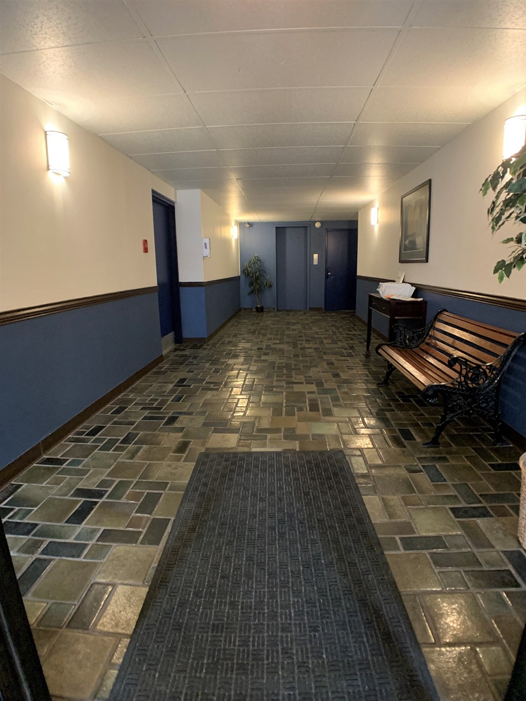 a large hallway with benches and blue doors