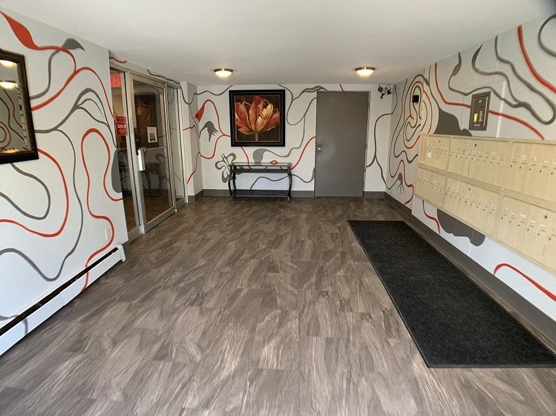 the lobby of a gym with a dance floor and a wall with a painting on