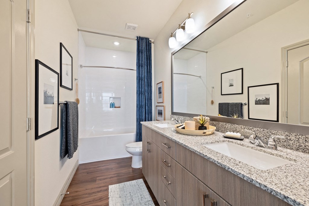Apartment bathroom with double vanity sinks and custom framed mirror