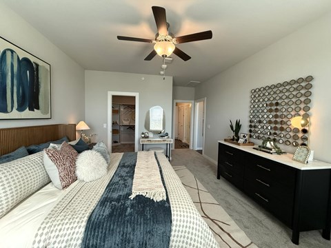 A bedroom with a large bed and a ceiling fan.