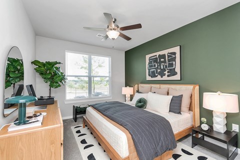 Apartment bedroom with ceiling fan and large window