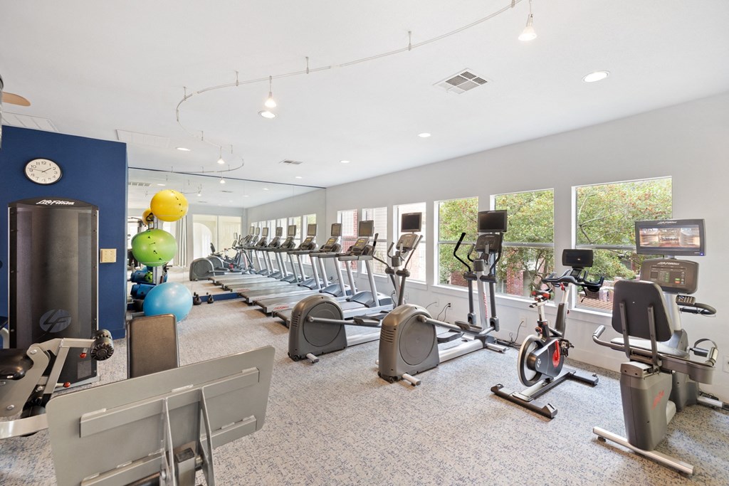 a spacious fitness center with cardio machines and weights