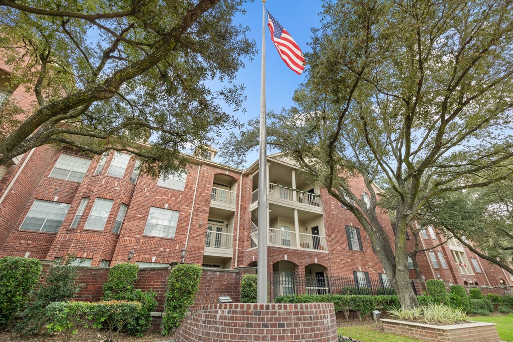 A flag pole with American flag in front of The Belmont