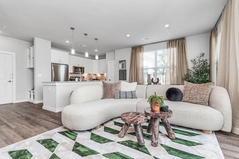 Living room and kitchen with wood style flooring and large, energy-efficient windows