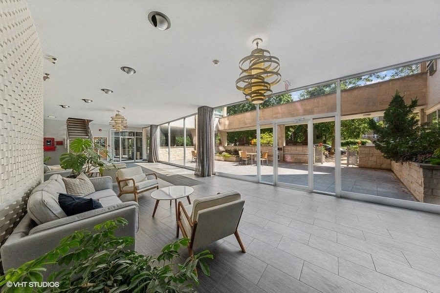 a living room with a couch and chairs in front of a large window