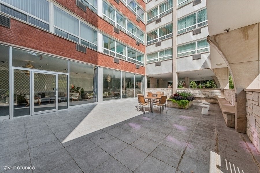 a courtyard with a table and chairs in front of an apartment building