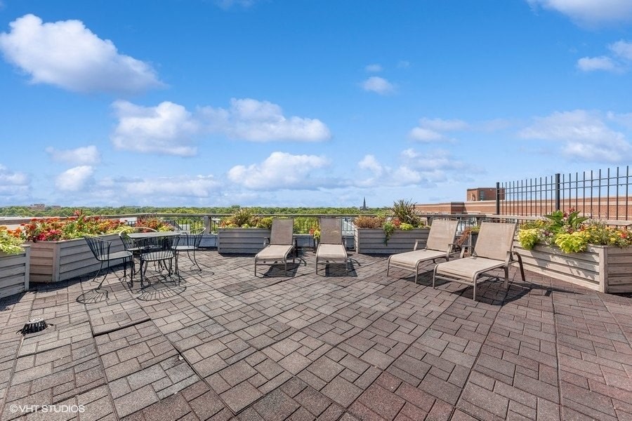 a patio with chairs and tables on a roof