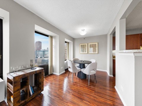 A dining room with a table set for two and a view of a city skyline.
