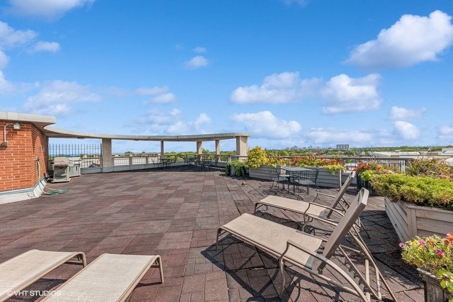 a rooftop patio with tables and chairs and a view of the city