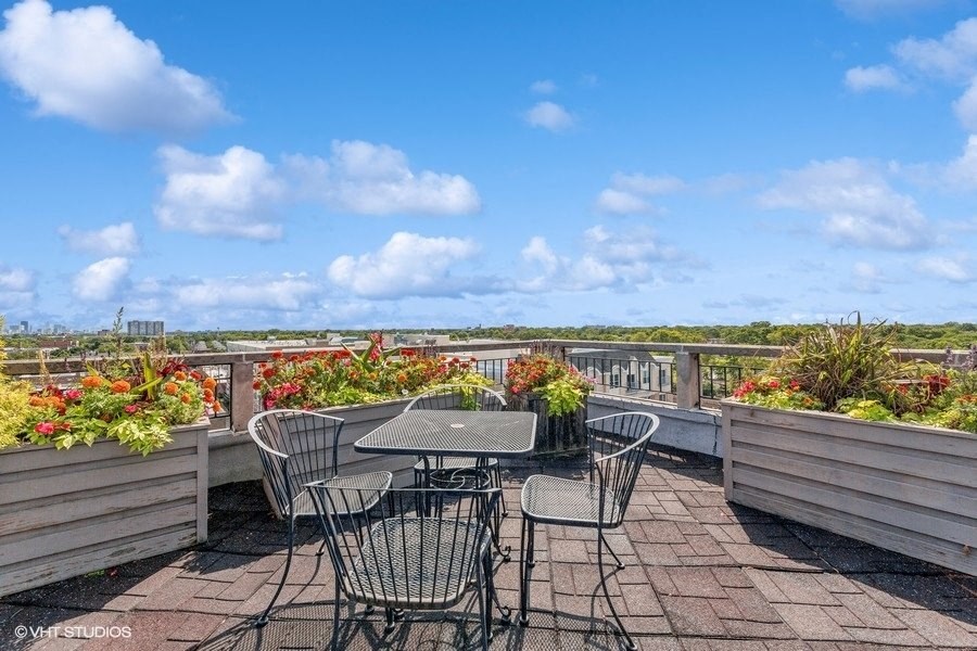 a patio with tables and chairs on top of a roof