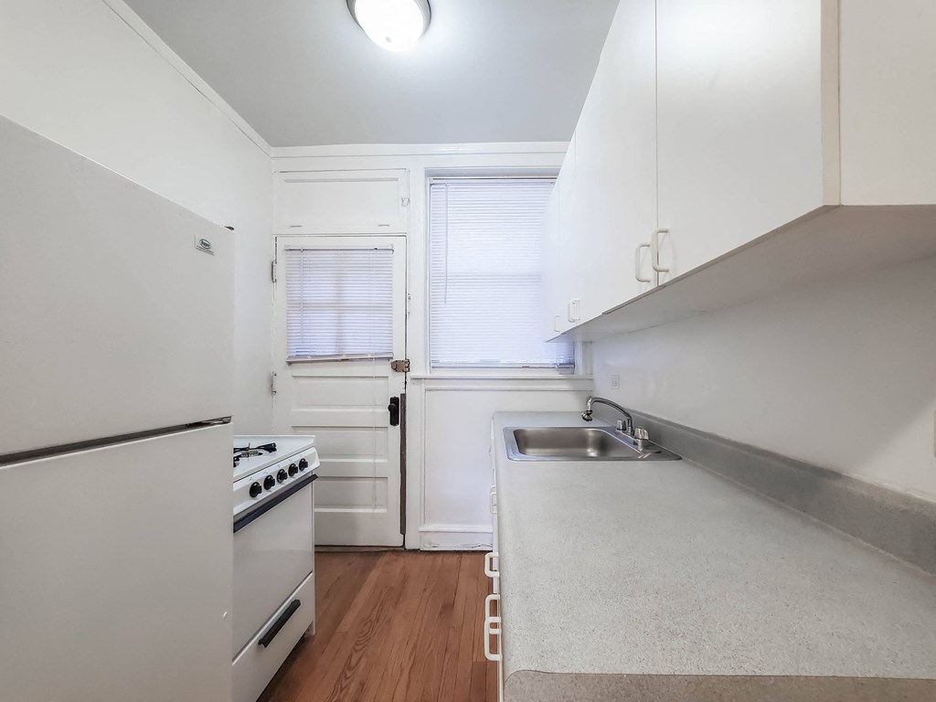 a kitchen with white cabinets and a white stove top oven