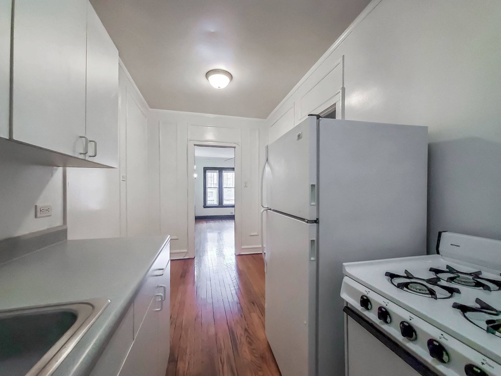 a kitchen with white cabinets and white appliances